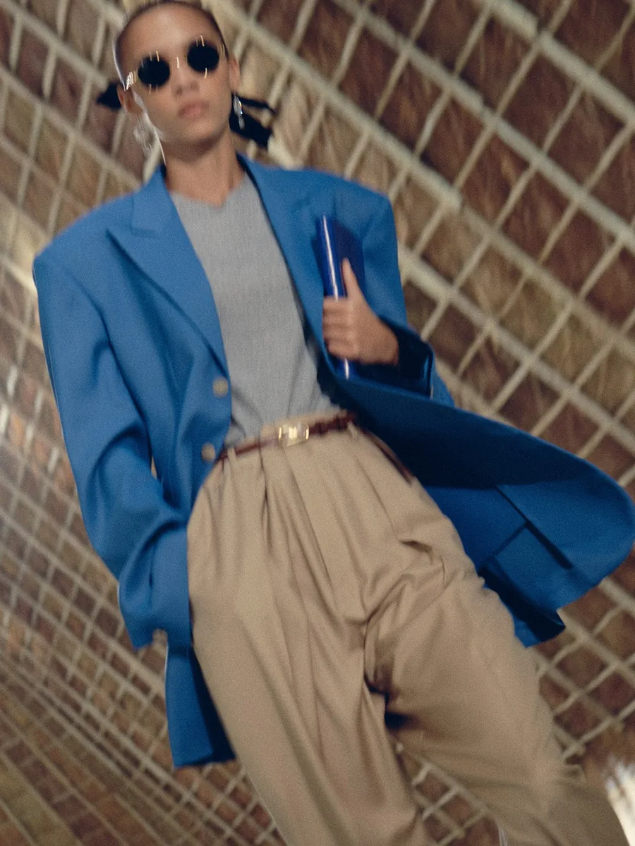 Celine Spring-Summer 2027 rehearsal: blue blazer over a grey top with beige trousers and round sunglasses