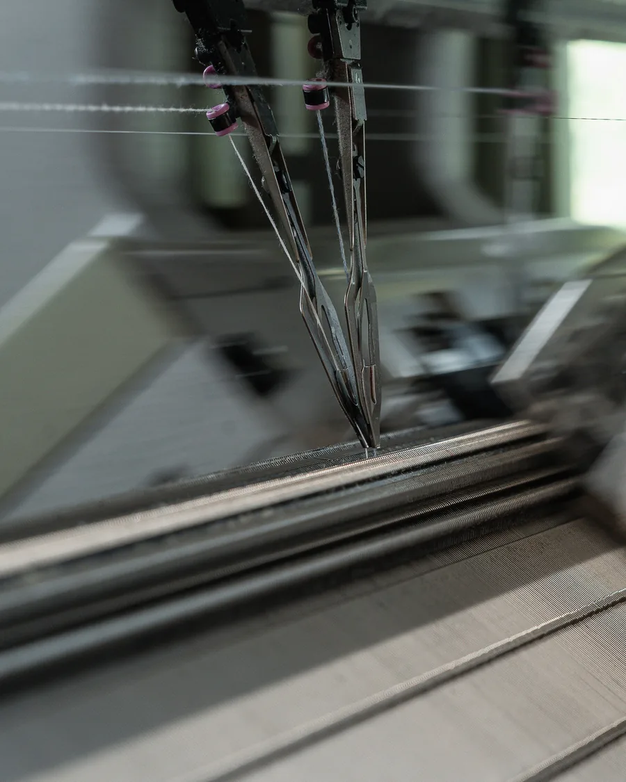 Needles and yarn of a knitting machine at work in the Loro Piana manufacture in Ghemme